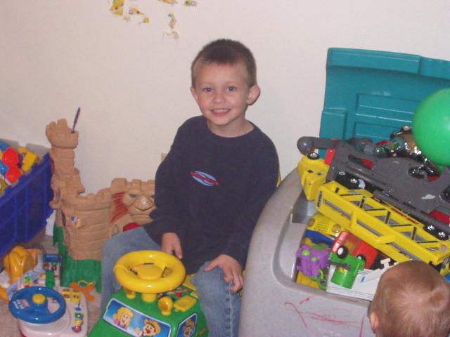 Timothy is sitting on his little brothers farm truck. He can't seem to find any other toys :):)