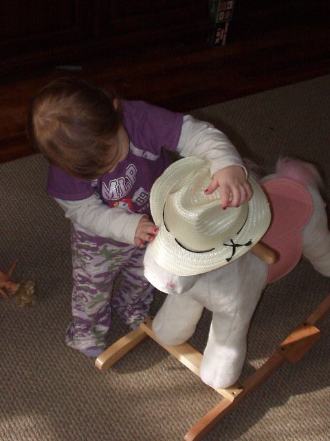 Abigail is letting her neigh-neigh try on the hat that Aunt Joni bought (for Abigail):)