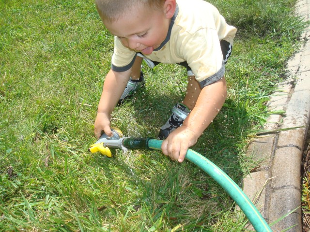 Playing in hose water feels good on a hot day.